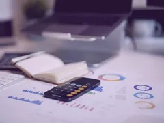 Financial report with charts and a calculator on a desk